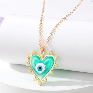 Détail collier cœur œil du diable doré avec émail bleu et perles sur support blanc