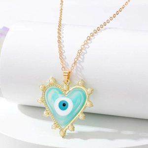 Détail du collier pendentif coeur avec motif oeil maléfique bleu et perles blanches