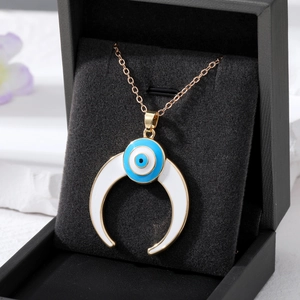 Golden Evil Eye necklace with white crescent moon pendant on black jewelry gift box