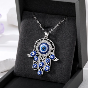 Détail du pendentif Main de Fatma avec yeux bleus dans un écrin à bijoux en cuir noir