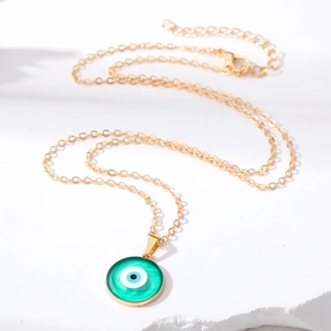 Golden Evil Eye necklace featuring a vibrant green pendant with blue and black details