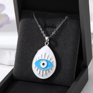 Detailed view of evil eye water drop pendant with white enamel and blue eye center