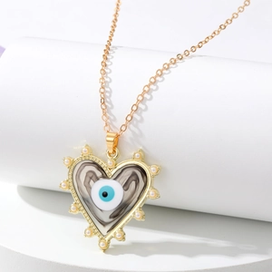 Détail du collier cœur doré avec mini perles et pendentif œil maléfique marbré