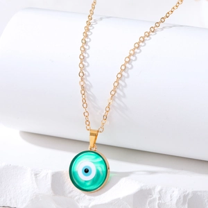 Detail of green evil eye pendant necklace with golden chain on white display stand