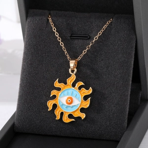 Detailed macro of golden sun flower pendant with evil eye on black velvet background