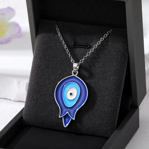 Detailed close-up of blue evil eye teardrop pendants displayed on a black velvet jewelry box