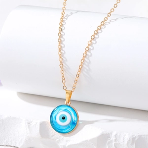 Minimalist evil eye pendant necklace with golden chain on white mineral display stand