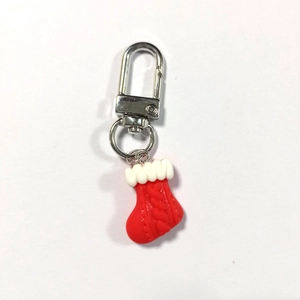 Dettaglio portachiavi a calza di Natale con trama a maglia e chiusura ad anello in metallo