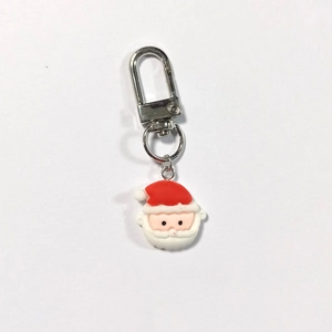 Dettaglio ravvicinato di un portachiavi di Babbo Natale in resina con chiusura a moschettone