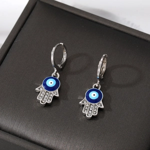 Hamsa hand earrings with blue evil eye and sparkling crystals in jewelry box