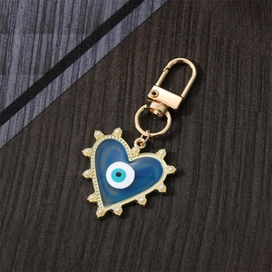 Porte-clés cœur doré avec émail œil bleu et bordure en perles au style minimaliste