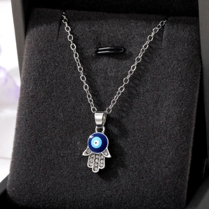 Silver Hamsa Hand necklace with blue evil eye and sparkling crystal rhinestones
