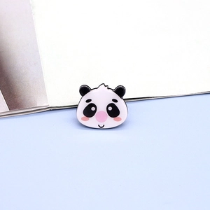 Macro shot of cute cartoon panda enamel pin badge with polished black and white finish