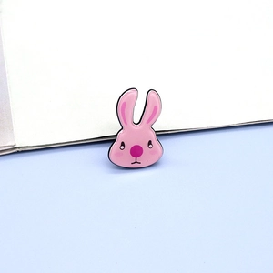 Close-up of a cute pink acrylic rabbit brooch pin with detailed black enamel outlines