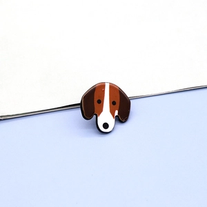 Detailed view of a cute resin beagle puppy pin badge with smooth brown and white finish