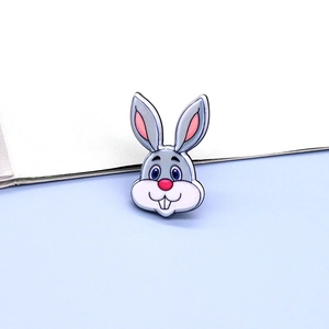 Detailed close-up of a cute gray rabbit acrylic brooch pin with big blue eyes and pink ears