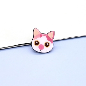 Close-up of a cute resin pink cartoon cat brooch with glossy finish and vibrant details