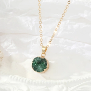 Detail van natuurlijke groene druzy hanger met goudkleurige rand aan een gouden ketting