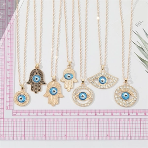 Détail de l'ensemble de 7 pendentifs Main de Fatma et Œil de Turquie en métal doré