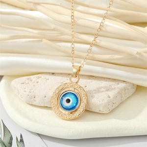 Gros plan du collier pendentif œil bleu doré sur pierre naturelle avec soie
