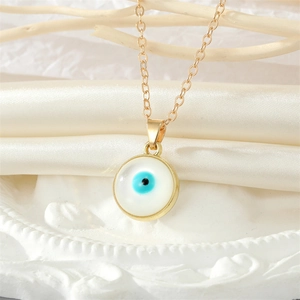 Elegant gold necklace featuring a classic blue Evil Eye circular pendant on silk background