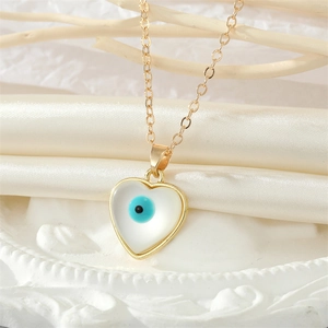 Detailed shot of a gold heart pendant with a blue evil eye and mother of pearl inlay