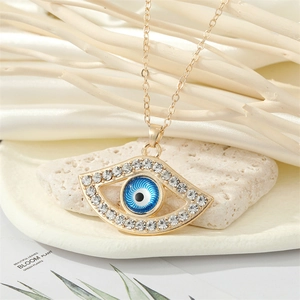 Collier vintage œil du diable doré avec centre bleu et cristaux sur support en pierre