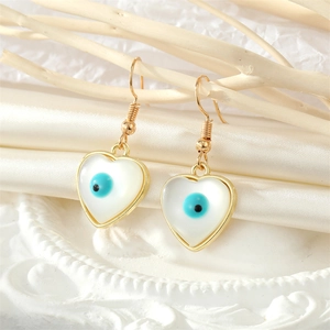 Elegant gold heart earrings with blue evil eye stone and opal finish on silk background