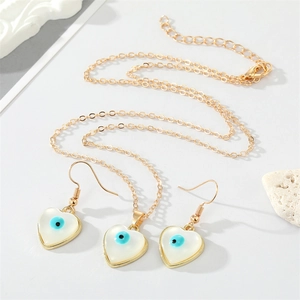 Detailed view of gold evil eye jewelry set featuring heart-shaped charms and cat eye stones