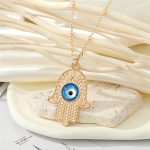 Vue détaillée du pendentif Main de Fatma avec œil bleu sur une chaîne plaquée or chic