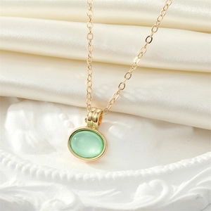 Vintage gold necklace featuring a translucent green round opal pendant on a fine chain