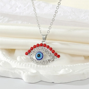 Retro Evil Eye necklace with red rhinestones and clear crystals on a silk background