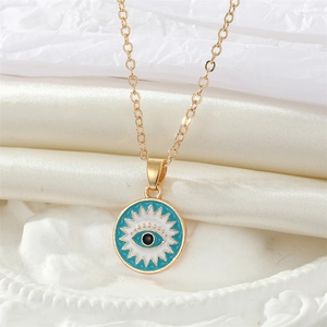 Vintage gold Evil Eye necklace with blue enamel sunburst pendant on silk background