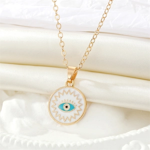Detailed macro view of the golden Evil Eye necklace pendant on white silk fabric