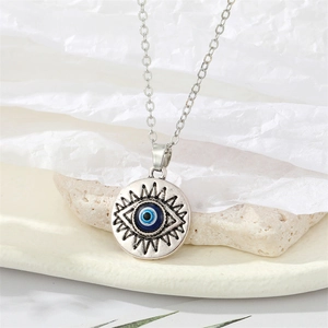 Vintage zilveren Evil Eye hanger ketting met blauwe kraal op minimalistische achtergrond
