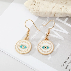 Vintage gold Evil Eye earrings with colorful enamel charms on a white stone background