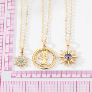 Size comparison of gold coin queen portrait pendant and starburst necklaces with stones