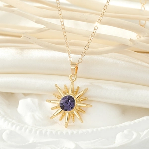 Golden Sun Queen pendant necklace with purple rhinestone on a silk and porcelain background