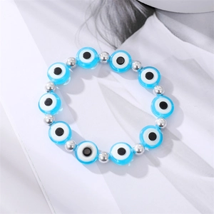 Turkish evil eye beaded bracelet with blue round charms and silver spacers on a magazine page