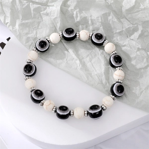 Bracelet fait main avec perles œil porte-bonheur noires et blanches et séparateurs en métal