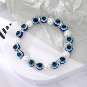 Détail des perles Mauvais Oeil avec perles d'imitation et intercalaires en cristal doré