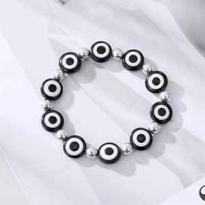 Retro evil eye beaded bracelet with silver metal spacers on a minimalist background