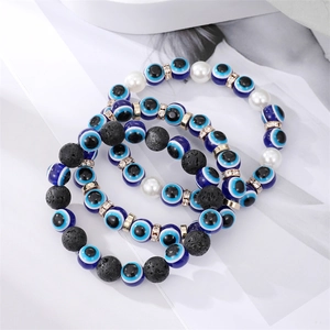 Détail du lot de bracelets œil maléfique avec pierres de lave noires et perles nacrées