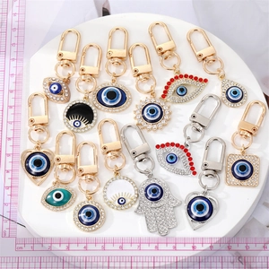 Macro shot of assorted Evil Eye and Hamsa hand charms with rhinestones and enamel