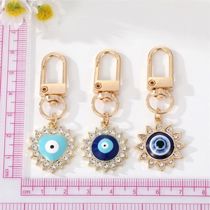 Detailed view of evil eye charms in heart and sun shapes with shiny gold alloy finish