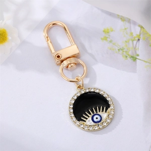 Detail of golden Evil Eye keychain with blue enamel inlay and sparkling rhinestones