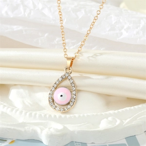 Primer plano del colgante de gota ojo malvado rosa con acabado dorado y pedrería brillante