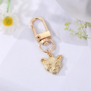 Detailed close-up of golden leopard head keychain with textured metal finish