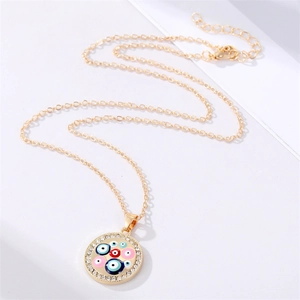 Detail of gold chain necklace featuring multi-color evil eye pendant with crystal inlay