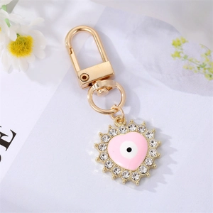 Golden alloy heart keychain with pink evil eye pendant and sun-shaped diamond accents